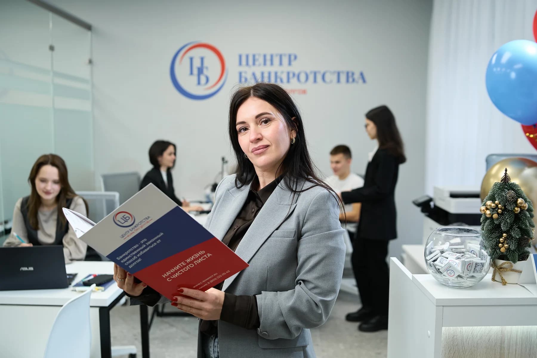 Юрист «Центра Банкротства» с памяткой клиенту в офисе